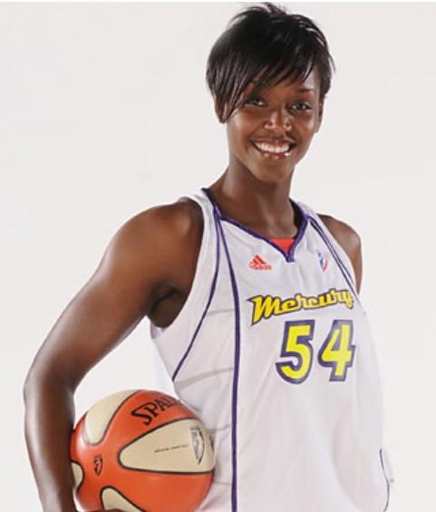 A Black woman wearing a basketball jersey that says "Mercury 54" is posing with a basketball