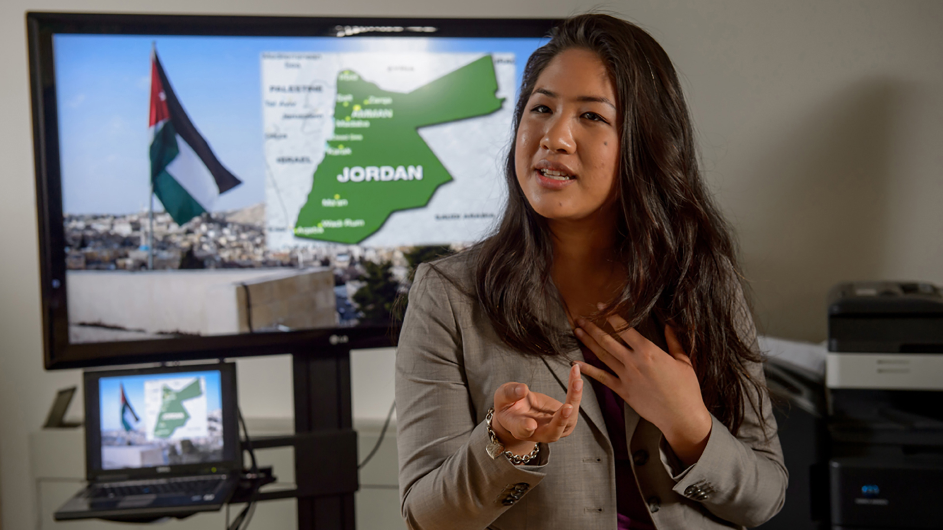 Student presents in front of a screen showing a map of Jordan 