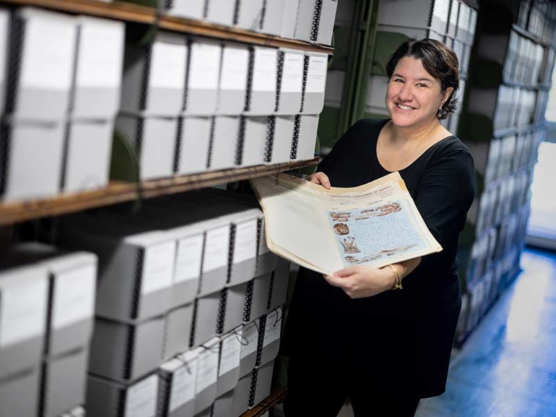 Elisabeth McMahon, associate professor of History and Africana Studies in the School of Liberal Arts, holds a folder of letters that are part of the African Letters Project