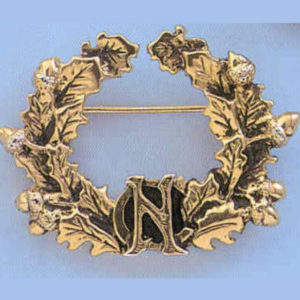 Image of 50 Year Alumnae Pin, a crescent-shaped pin in gold featuring acorns, oak leaves, and the letters NC