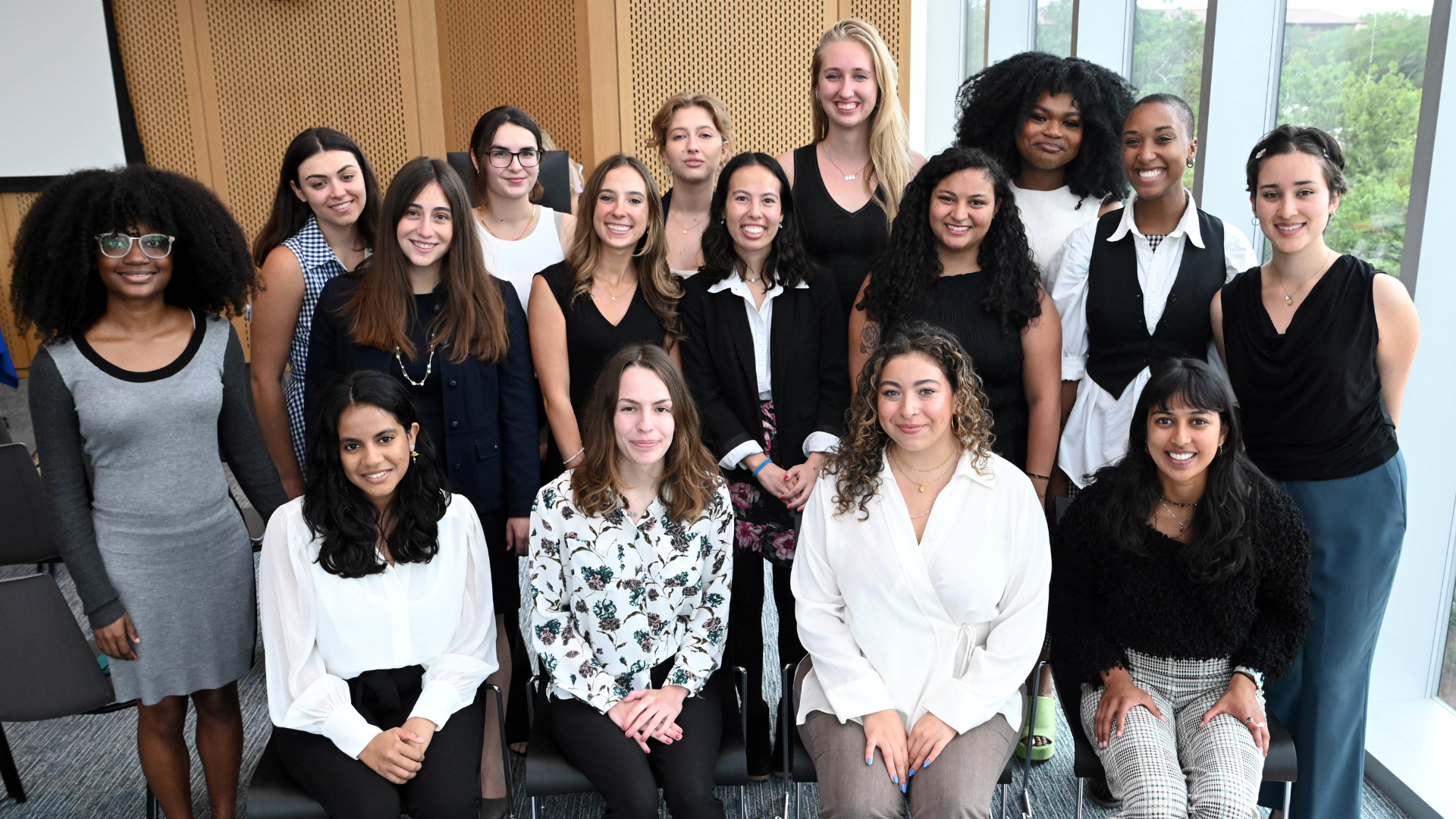 Newcomb Scholars, class of 2023. Students pose in group for photo in front of glass windows. 