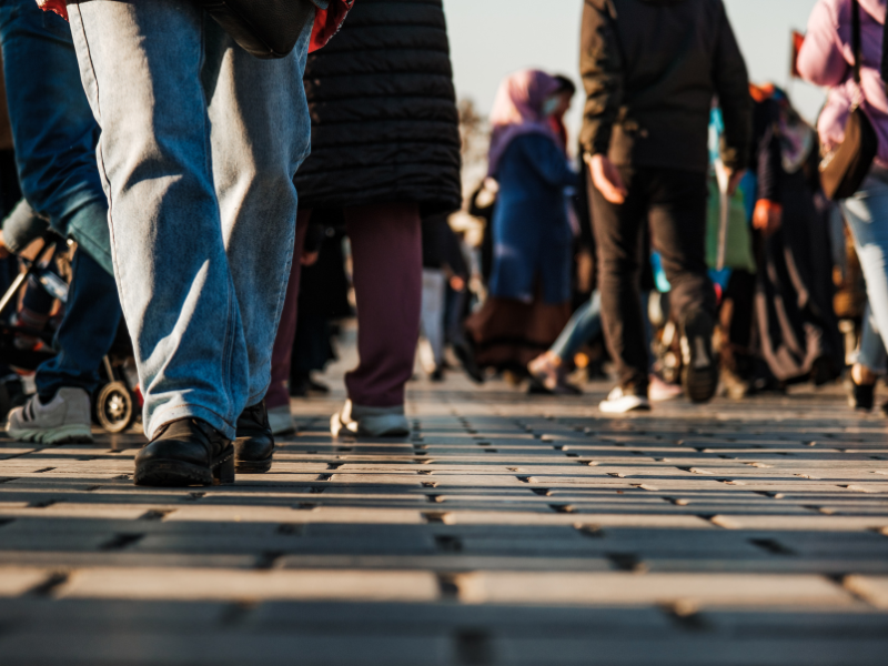 Photo of legs of people walking outside on a sidewalk