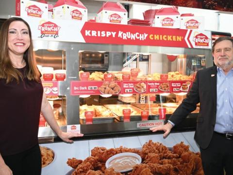 Allie Shapiro Dandry stands next to a Krispy Krunchy food display