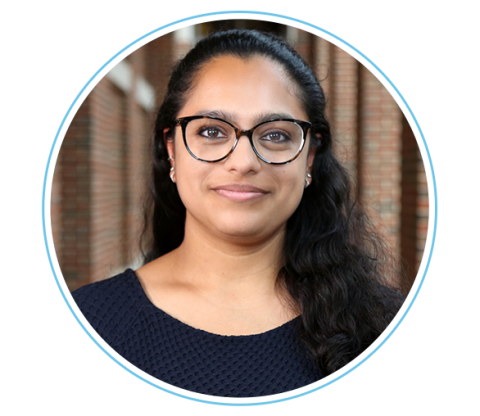 Smiling woman with dark hair and glasses.