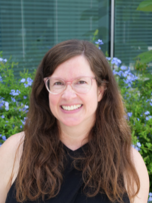 Photo of Elizabeth Hearne - Headshot photo taken outside in front of blue flowers