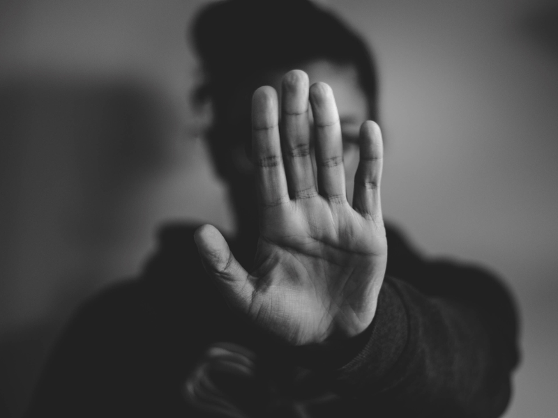 black and white photo of woman holding her hand in "stop" motion