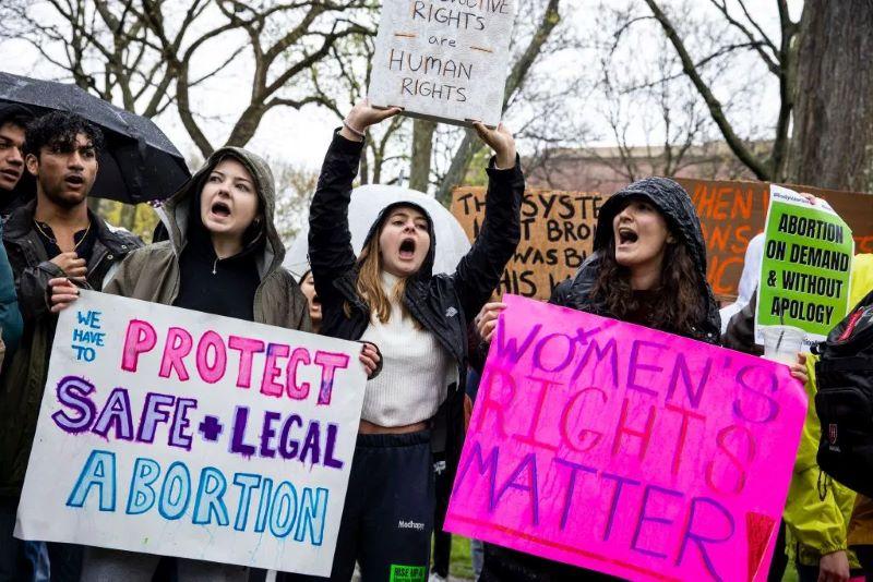 A protest for abortion legalization gathers with signs that say "We have to protect safe and legal abortion" and "Women's rights matter"