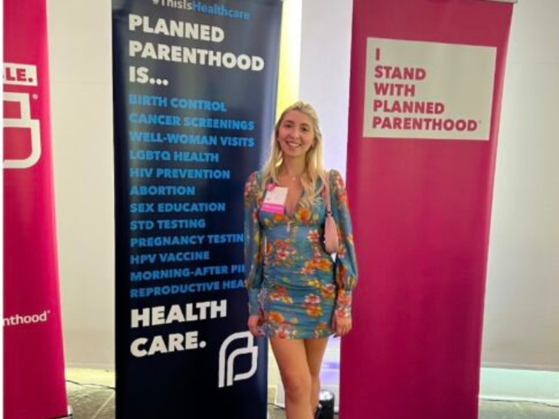 Zoe Burnett in front of Planned Parenthood banners