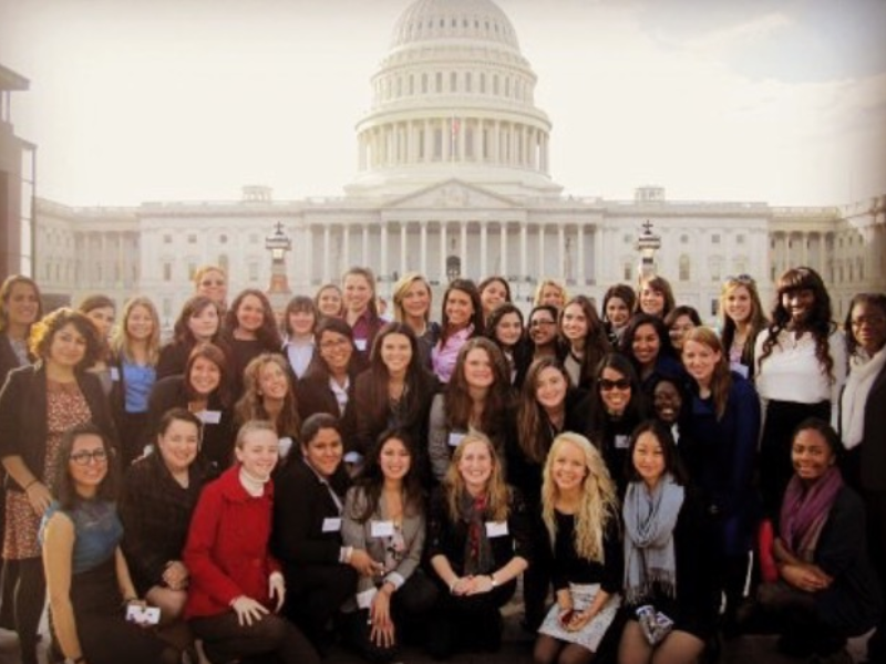 Allison Buffett with group of interns in front of capital