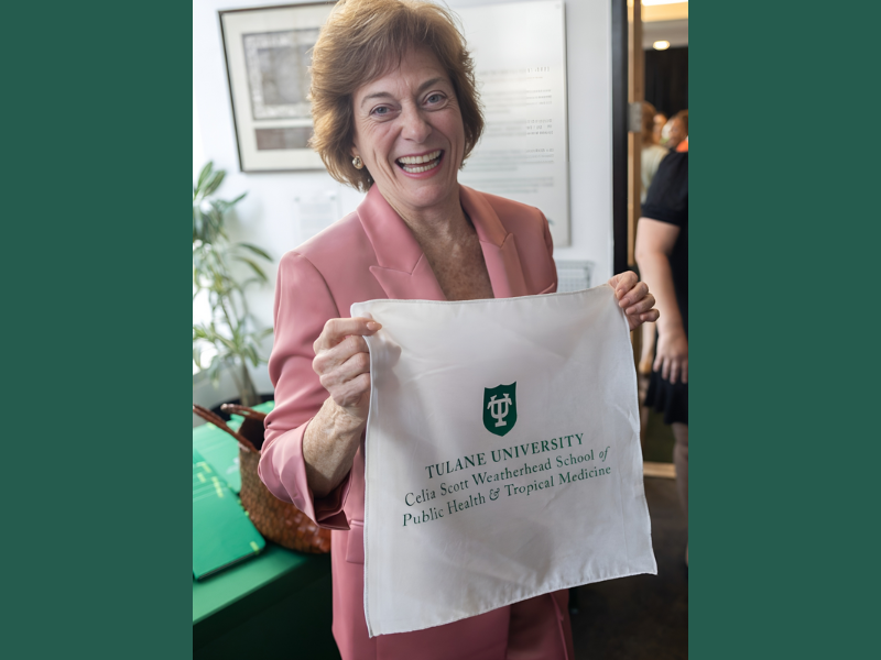 Celia Scott Weatherhead holding up handkerchief with the new name of the School of Public Health & Tropical Medicine 