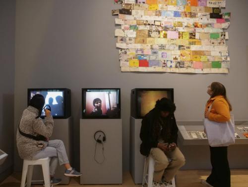 Students sit and stand in front of interactive art exhibits